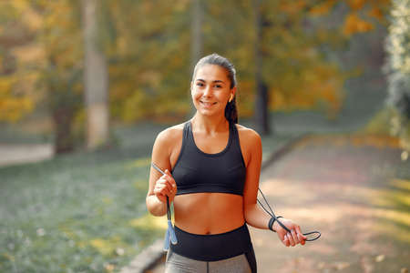 Sports girl in a black top training in a autumn parkの写真素材