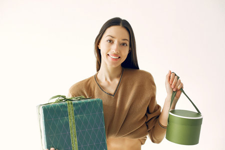 Beautiful girl standing in a studio with presents