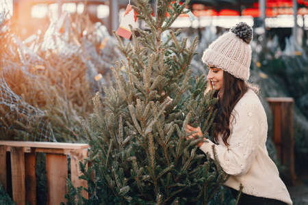 Cute brunette in a white sweater with Christmas treeの写真素材
