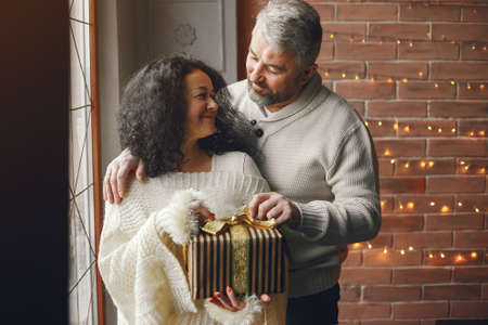 Senior couple with gifts near the Christmas treeの写真素材