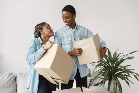 Couple with boxes moving into new home smilingの写真素材
