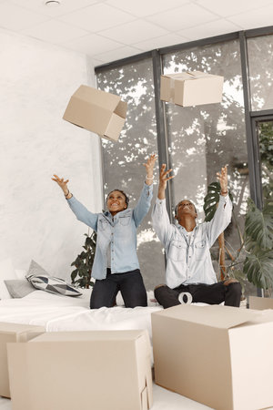 Couple with boxes moving into new home smilingの写真素材