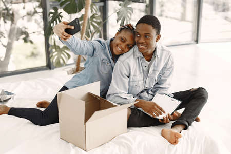 Couple with boxes moving into new home smilingの写真素材