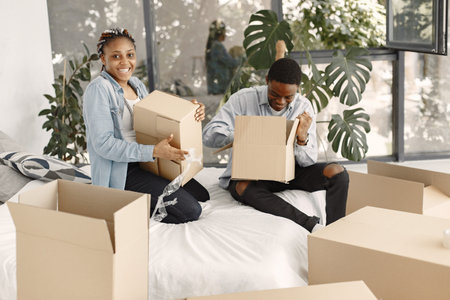Couple with boxes moving into new home smiling