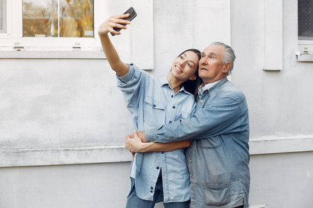 Girl teaching her grandfather how to use a phone