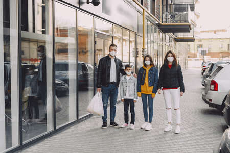 Family in protective masks with purchasesの写真素材