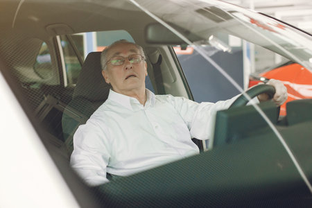 Elegant old man in a car salon