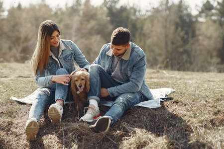 Cute couple in a jeans clothes in a spring fieldの写真素材