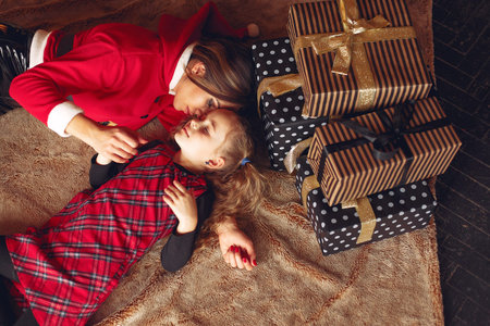 Mother with cute daughter at home near fireplace