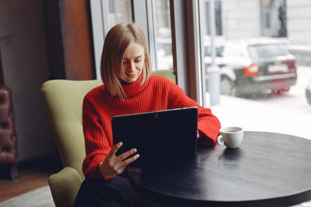 Businesswoman in a red sweater works