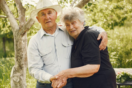 Beautiful old couple spend time in a summer garden