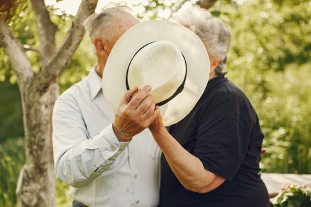 Beautiful old couple spend time in a summer garden