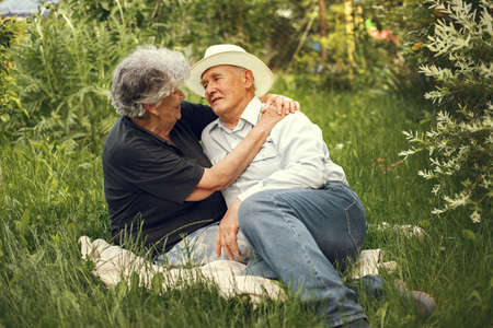 Beautiful old couple spend time in a summer gardenの写真素材