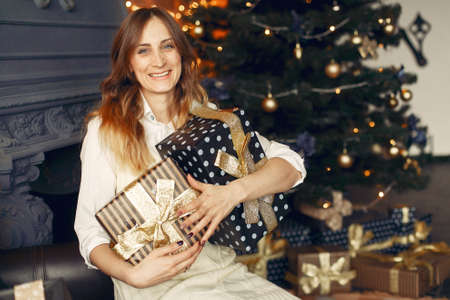 Beautiful girl at home near christmas treeの写真素材