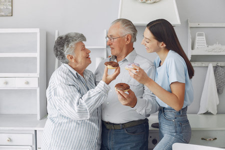 Old couple in a kitchen with young granddaughter
