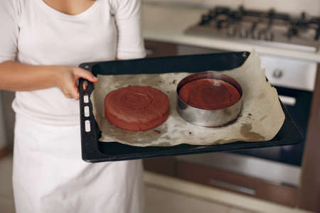 Confectioner takes the finished cake out of the oven.の写真素材
