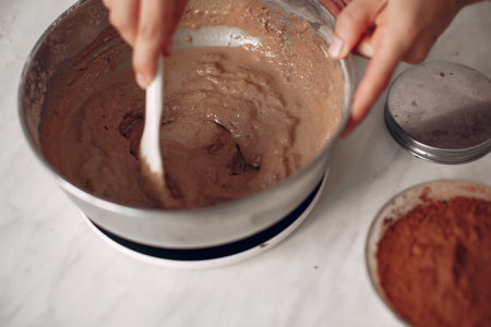 Chef in white clothes prepares a chocolate cake.