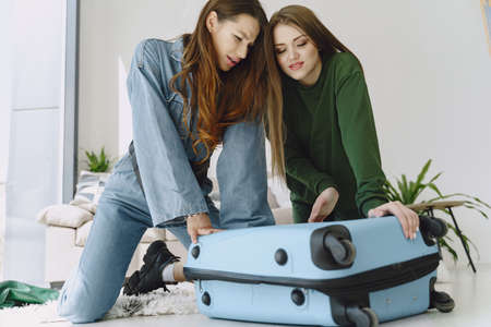 Women prepare travel suitcase at homeの写真素材