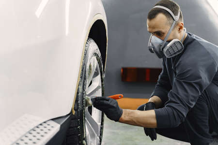 Male hand with foam sponge washing carの写真素材