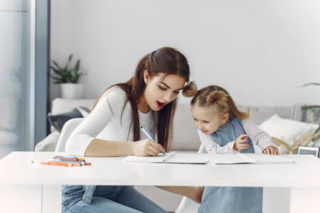 Tutor with litthe girl studying at homeの写真素材