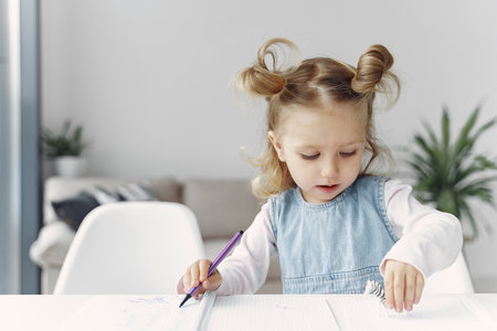 Little girl sitting on a table with booksの写真素材