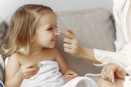 Mother with daughter in bathrobe and towelsの写真素材