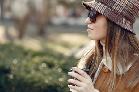 Girl walking in a spring sity and hold coffee in her handの写真素材