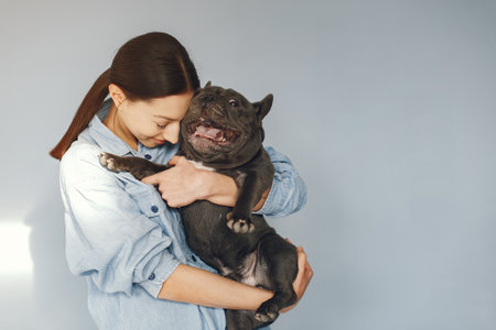 Elegant woman in a blue shirt with black bulldogの写真素材
