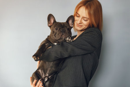 Elegant woman in a black suit with black bulldogの写真素材