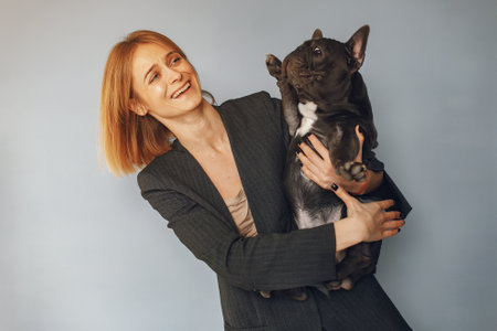 Elegant woman in a black suit with black bulldogの写真素材
