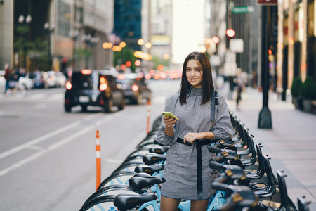 girl renting a city bike from a bike stand