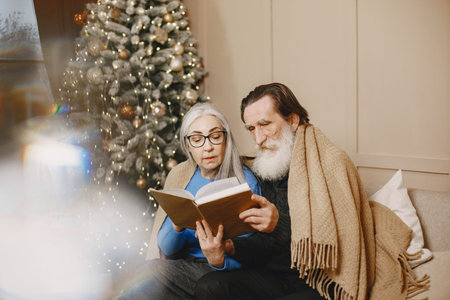 Senior couple with book near the Christmas tree