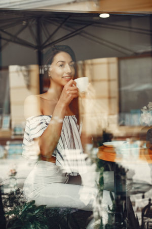 Fashion young girl in a summer cafeの写真素材