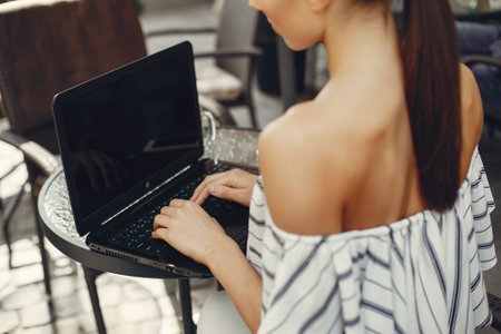 Fashion young girl sitting in a summer cafeの写真素材