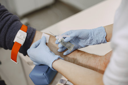 Nurse taking blood sample from patient at the doctors officeの写真素材