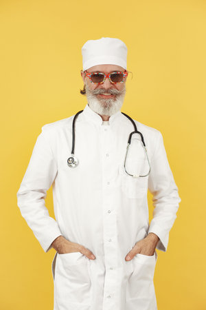Old doctor standing in a white uniform