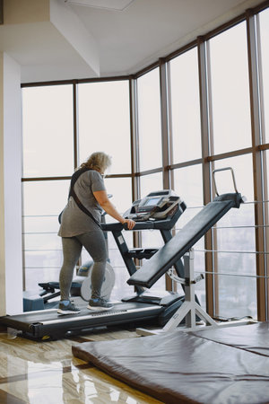 Adult fat woman doing gymnastics at the gym