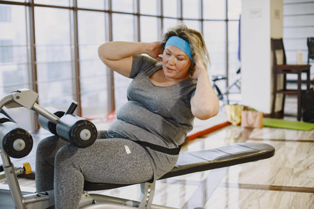 Adult fat woman doing gymnastics at the gym
