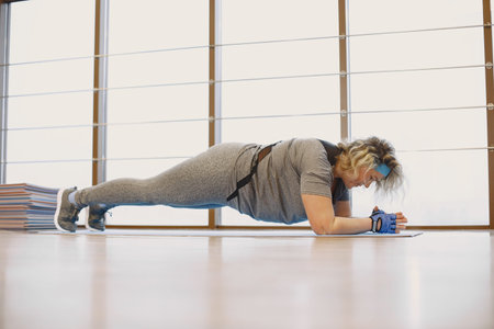 Adult fat woman doing gymnastics at the gym
