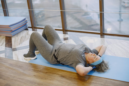 Adult fat woman doing gymnastics at the gym