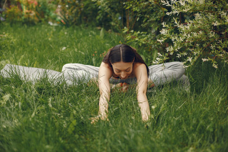 Woman practicing advanced yoga in a parkの写真素材