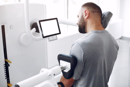 Bearded man having rehabilitation after injury in physiotherapy clinic
