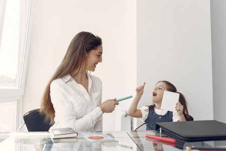 Tutor with litthe girl studying at homeの写真素材
