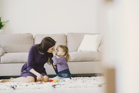 Cheerful mom playing laughing with little kid daughterの写真素材
