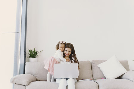 Woman with daughter using laptop computerの写真素材
