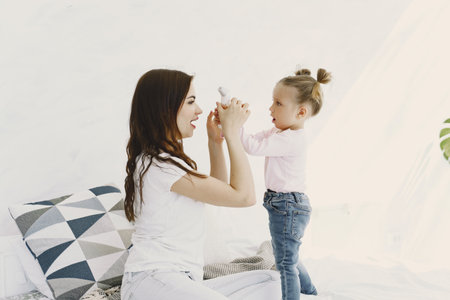 Mother with thermometer is sitting near daughterの写真素材