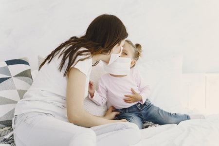 Mother and baby at home with medical masksの写真素材