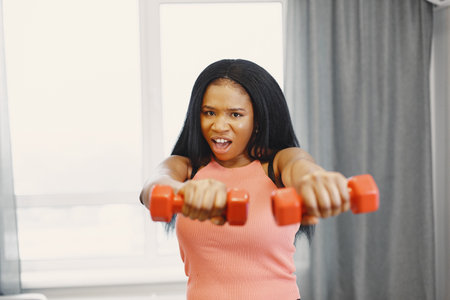 Afro American sportswoman working out at home