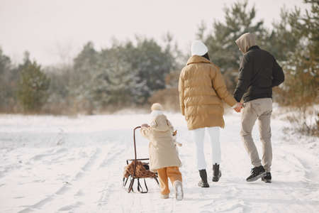 Family in winter clothes play in winter forestの写真素材