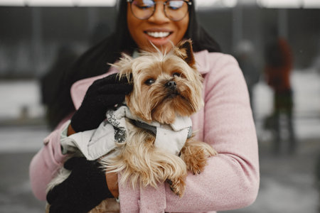African woman walks with dog outdoors